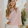 Font view of model wearing the Brooklyn Sweater Vest In Blush which features blush knit fabric, turtleneck neckline, high- low hem and sleeveless.