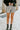 Front view of model wearing the Silver Lining Shorts that feature silver sheen fabric, an elastic smocked waistband, and a lining.
