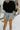 Back view of model wearing the Silver Lining Shorts that feature silver sheen fabric, an elastic smocked waistband, and a lining.