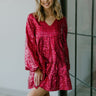 Close up view of model wearing the Make It Yours Sequin Dress which features hot pink sequin fabric, v neckline, has a lining, tiered style and long balloon sleeves with elastic wrists.