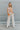 Full body front view of model wearing the Turn Back Time Top that has cream sheer fabric with mustard and brown pattern details, fabric covered buttons, a collared neckline, and long balloon sleeves with smocked wrists