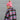 Side view of model wearing the Summit Beanie in Pink that features pink knit fabric, folded trim with a "C.C." emblem, and a faux fur pompom.