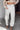 Front view of model wearing the Hudson Corduroy Cargo Pants that have off white corduroy fabric, light brown stitching, side front and back pockets, belt loops and wide legs