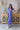 Front view of model wearing the Summertime Blues Maxi Dress that features royal blue fabric with a white floral print, maxi length, a slit on the side, a front tie closure, a surplice neckline and short sleeves