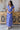Front view of model wearing the Summertime Blues Maxi Dress that features royal blue fabric with a white floral print, maxi length, a slit on the side, a front tie closure, a surplice neckline and short sleeves