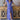 Front view of model wearing the Summertime Blues Maxi Dress that features royal blue fabric with a white floral print, maxi length, a slit on the side, a front tie closure, a surplice neckline and short sleeves