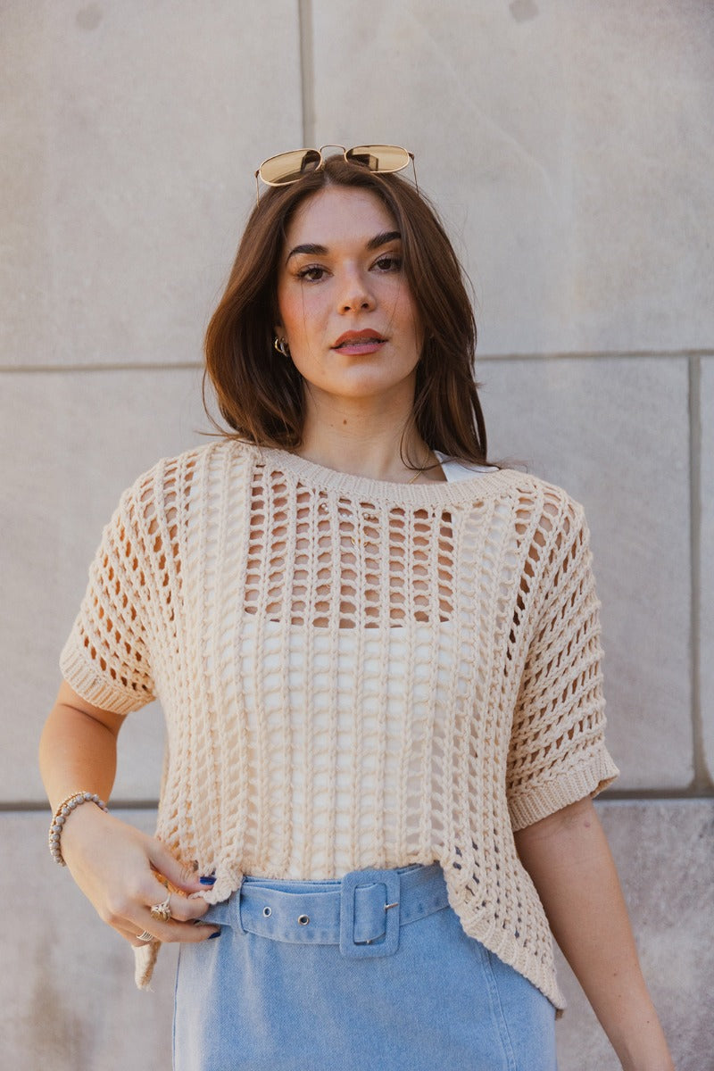 Front view of model wearing the Helen Beige Open Knit Top which features beige open knit fabric, thick hem, round neckline and short sleeves.