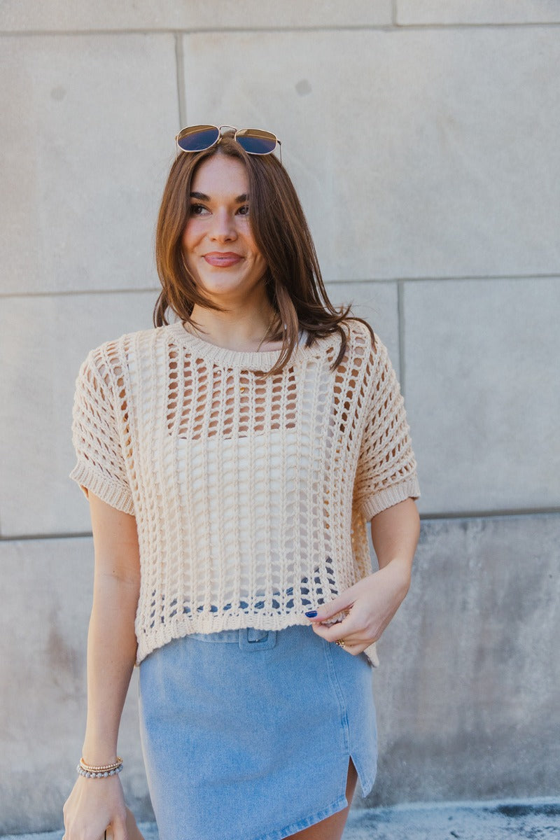 Front view of model wearing the Helen Beige Open Knit Top which features beige open knit fabric, thick hem, round neckline and short sleeves.