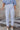 Front view of model wearing the Rebecca White Denim Fray Straight Leg Jeans which features white denim fabric, front zipper with button closure, two front pockets, two back pockets, belt loops, high rise and straight pant legs with fray hem.