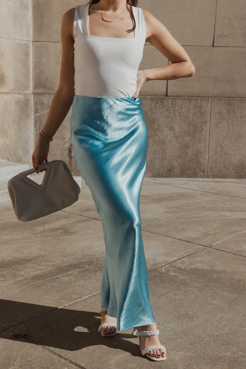 Front view of model wearing the Nova Aqua Blue Satin Midi Skirt which features turquoise satin fabric, maxi length, elastic band and monochrome side zipper with hook closure.