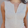 Front view of model wearing the Isla Heather Grey Zip Up Sleeveless Bodysuit which features light heather grey knit fabric, a monochrome front zip up, a round neckline, a sleeveless body, and a thong bottom with snap closures.