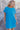 Front view of model wearing the Skylar Blue Short Sleeve Mini Dress that has ocean blue cotton fabric, mini length, two side pockets, a left chest pocket, a round neck, and short sleeves with folded hems.