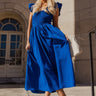 Full body front view of model wearing the Kristina Royal Blue Smocked Sleeveless Midi Dress that has royal blue fabric, side slit pockets, midi length, smocked upper, a scoop neckline, and ruffled straps.