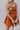 front view of model wearing the Falling For You Dress that has burnt orange fabric, mini length, burnt orange lining, a flare skirt with a tiered ruffle design, a square neckline, thick straps, and a monochromatic back zipper