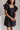 Front view of model wearing the Love Is In The Air Dress that has black woven fabric, pockets on each side, a square neckline, and short ruffle sleeves