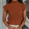 Front view of model wearing the Sawyer Mock Neck Top features rust brown knit fabric, a scalloped hem, a high neckline and short sleeves.