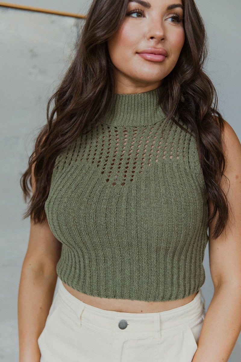 Close up view of model wearing the I Go Back Tank in Olive which features olive green chenille knit fabric, high neckline and sleeveless.