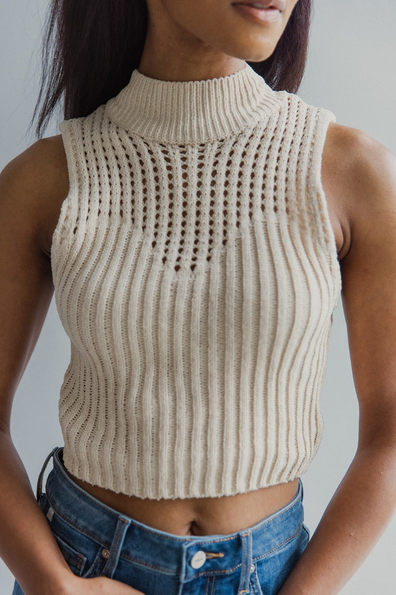 Close up view of model wearing the I Go Back Tank in Natural which features cream chenille knit fabric, a high neckline and a sleeveless design.