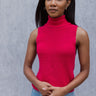 Front view of model wearing the Rule The World Tank in Pink which features hot pink cable knit fabric, a turtle neck neckline and a sleeveless design.