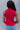 Back view of model wearing the Rule The World Tank in Pink which features hot pink cable knit fabric, a turtle neck neckline and a sleeveless design.