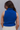 Back view of model wearing the Rule The World Tank in Blue which features cobalt blue cable knit fabric, a turtle neck neckline, and a sleeveless design.