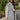 Close side view of model wearing The Ready to Go Shacket which features color-blocked grey and tan corduroy fabric, a button-up front with a collared neckline, long sleeves with buttoned wrists, front chest pockets, and side pockets.