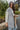Close side view of model wearing The Ready to Go Shacket which features color-blocked grey and tan corduroy fabric, a button-up front with a collared neckline, long sleeves with buttoned wrists, front chest pockets, and side pockets.