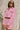 Front view of model wearing the Live Your Best Life Cropped Blazer, which has a pink tweed material, a collar neck, a cuffed long sleeve with a button detail, a button-up front, two front pockets, and a cropped fit