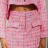 Close-up front view of model wearing the Live Your Best Life Skort, whcih features a pink tweed material, a high-rise fit, a button and zipper front closure, two front pockets, and a shorts back