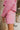 Close-up side view of model wearing the Live Your Best Life Skort, whcih features a pink tweed material, a high-rise fit, a button and zipper front closure, two front pockets, and a shorts back