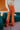 Frontal view of the Missed Decade Flare Pants that features an orange colored corduroy material, a high-rise waist, a button and zipper front closure, faux front pockets, two back pockets, and a flare fit.