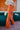 Side view of the Missed Decade Flare Pants that features an orange colored corduroy material, a high-rise waist, a button and zipper front closure, faux front pockets, two back pockets, and a flare fit.