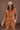 Front view of model wearing the More Than Enough Romper In Camel, which has a camel corduroy material, a collar neck, a surplice front, a long sleeve with a button, a front zipper, pockets, and pleating on the legs.