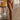 Frontal view of the Next Level Straight Leg Pants that features a brown faux-leather material, a high-rise fit, a clasp and zipper front closure, belt loops, two front pockets, a middle seam down the legs, and a straight leg fit