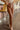 Frontal view of the Next Level Straight Leg Pants that features a brown faux-leather material, a high-rise fit, a clasp and zipper front closure, belt loops, two front pockets, a middle seam down the legs, and a straight leg fit