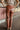 Back view of the Next Level Straight Leg Pants that features a brown faux-leather material, a high-rise fit, a clasp and zipper front closure, belt loops, two front pockets, a middle seam down the legs, and a straight leg fit