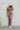 Full body view of model wearing The Work It Out Tie Pant which features soft mocha-colored ribbed fabric, an elastic drawstring waist, and wide legs with side slits.