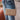 The Keep Your Cool Purse is a crossbody style, featuring a natural colored faux leather, a quilted design, a crossbody chain, a zip and card pockets within, and a button closure.