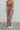 Front view of model wearing The Work It Out Tie Pant which features soft mocha-colored ribbed fabric, an elastic drawstring waist, and wide legs with side slits.