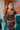 Frontal view of the Everglow Crop Top that features a black colored material, a multi-colored floral print, a straight neckline with a ruffle detail, a short sleeve, a back zipper closure, and a cropped fit