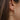 Close side view of model wearing the Color Your World Hoop Earrings, which feature thin open gold hoops with multi-colored dots.