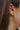 Close side view of model wearing the Color Your World Hoop Earrings, which feature thin open gold hoops with multi-colored dots.
