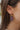 Close side view of model wearing the Party Time Earrings, which feature gold teardrops filled with multi-colored glitter.