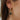 Close side view of model wearing the Date Night Earring, which features open gold hoops with clear rhinestones and a rectangular square pendant.