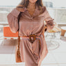 Frontal view of the Balanced Out Mini Dress that features a pink colored silk material, a a collar and lapel neckline, a button-up front, a long cuffed sleeve, a front pocket, a curved hemline, and a midi length.