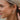 Close side view of model wearing the In Bloom Earrings, which feature gold half flowers on post backs with white pearl beading.