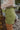 Close side view of model wearing the Loved You First Corduroy Skirt that has green corduroy with a front zipper closure, belt loops, front pockets, faux back pockets, and a front skirt overlay.