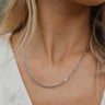 Close front view of model wearing the My Love Necklace in Silver, which features a silver link chain attached to two small link chains.