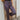 Close front view of model wearing the On To The Next Pants, which feature stretchy textured fabric with a black, blue, purple, and cream geometric print, a high-rise elastic waist, and straight legs.