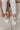 Aerial view of the Newport Sneakers, which have white uppers, white chunky soles, sage green laces, and a sage green heel tab. Shoe are shown on model's feet.
